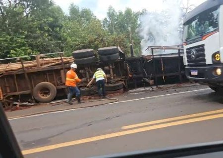 Carreta com eucalipto tomba e &eacute; consumida pelo fogo na BR-262